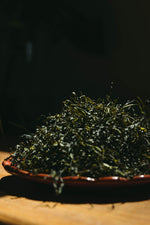 Dried Wakami seaweed on a wooden plate with a dark background